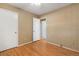 A cozy bedroom with hardwood floors, textured wallpaper, and a white ceiling fan and door at 2698 S Niagara St, Denver, CO 80224