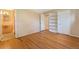 A bedroom with hardwood flooring and a view to a bathroom and built in shelves at 2698 S Niagara St, Denver, CO 80224