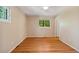 Bright bedroom with hardwood floors, neutral walls, and a window view of lush green trees at 2698 S Niagara St, Denver, CO 80224