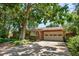 Ranch home with brick exterior, attached garage and mature shade tree on a sunny day at 2698 S Niagara St, Denver, CO 80224