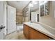 Well-lit bathroom featuring a single sink vanity, tiled shower/tub, and linen shelving unit at 16643 E 101St Ave, Commerce City, CO 80022