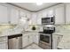 Well-lit kitchen with stainless steel appliances, light countertops and white cabinets at 795 S Alton Way # 4C, Denver, CO 80247