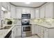 Well-lit kitchen with granite countertops, stainless steel appliances, and white cabinets at 795 S Alton Way # 4C, Denver, CO 80247