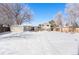 Snowy backyard with a view of the house, garden beds, and privacy fence at 3582 Wright St, Wheat Ridge, CO 80033