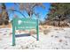 Lewis Meadows neighborhood sign in Wheat Ridge, Colorado, on a snowy day with trees and a blue sky in the background at 3582 Wright St, Wheat Ridge, CO 80033