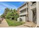 Exterior view of a condo building showcasing balconies, trees, green lawn, pathway, and building number at 14214 E 1St Dr # B08, Aurora, CO 80011