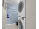 Functional laundry area featuring stacked washer and dryer with shelving for storage and tiled floors at 14214 E 1St Dr # B08, Aurora, CO 80011