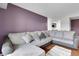 Spacious living room showcasing a large sectional couch, hardwood floors, and a modern accent wall at 14214 E 1St Dr # B08, Aurora, CO 80011