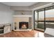 Well-lit living room featuring hardwood floors, fireplace, access to balcony, and neutral paint scheme at 14214 E 1St Dr # B08, Aurora, CO 80011