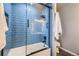 Stylish bathroom with blue subway tiles, glass shower doors, and modern fixtures at 3268 E 136Th Pl, Thornton, CO 80602