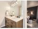 Bathroom with a double sink vanity, modern fixtures, and a glimpse of the primary bedroom at 3268 E 136Th Pl, Thornton, CO 80602