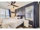 Serene bedroom with a modern accent wall, large windows, and comfortable furnishings at 3268 E 136Th Pl, Thornton, CO 80602
