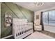Charming Bedroom with a modern accent wall, stylish crib, and comfortable seating at 3268 E 136Th Pl, Thornton, CO 80602