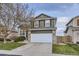 Traditional two-story home featuring a white garage door and a manicured front yard at 3268 E 136Th Pl, Thornton, CO 80602