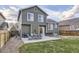 Exterior of home featuring well-maintained lawn and patio with outdoor furniture at 3268 E 136Th Pl, Thornton, CO 80602