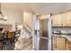 Well-lit kitchen featuring stainless steel refrigerator, knotty pine cabinets, and adjacent dining area at 3268 E 136Th Pl, Thornton, CO 80602