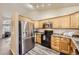 Efficient kitchen featuring stainless steel appliances, light wood cabinets, and granite counters at 3268 E 136Th Pl, Thornton, CO 80602