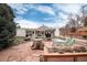 Spacious backyard with a stone patio, pergola-covered area, mature trees, and landscaping, perfect for outdoor living at 7794 Louviers Blvd, Louviers, CO 80131