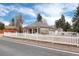 Side view of home showcases white picket fence and well-maintained landscaping at 7794 Louviers Blvd, Louviers, CO 80131