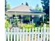 Charming home exterior with colorful flower garden, white picket fence, and welcoming front porch at 7794 Louviers Blvd, Louviers, CO 80131