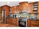 Modern kitchen with wooden cabinets, stainless steel appliances, and a backsplash at 7794 Louviers Blvd, Louviers, CO 80131