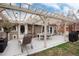 Covered patio with comfortable seating, dining area, and a well-maintained pergola, perfect for outdoor entertaining at 7794 Louviers Blvd, Louviers, CO 80131