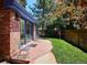 A well maintained backyard features a brick patio, grassy lawn, and a home with blue trim at 2504 S Garfield St, Denver, CO 80210