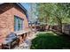 A backyard features an outdoor kitchen, dining area, seating, and grassy lawn at 2504 S Garfield St, Denver, CO 80210