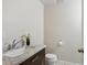 Half bathroom with a marble countertop, dark wood vanity, and tiled floors at 2504 S Garfield St, Denver, CO 80210