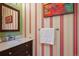 Charming powder room with a marble vanity and striped wallpaper at 2504 S Garfield St, Denver, CO 80210