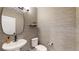 Stylish powder room with modern sink, toilet, and textured wallpaper at 2980 E 102Nd Pl, Thornton, CO 80229