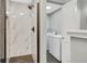 The updated shower and laundry room of this house offer convenience and contemporary design at 6842 Garland St, Arvada, CO 80004