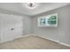Bright bedroom featuring carpeted floor, ceiling fan and a window with view of yard at 6842 Garland St, Arvada, CO 80004