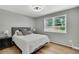Cozy bedroom with a comfortable bed, wood floors, and a large window overlooking the backyard at 6842 Garland St, Arvada, CO 80004