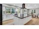 Spacious kitchen with a large island, modern appliances, light wood floors, and backyard views at 6842 Garland St, Arvada, CO 80004