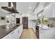 Modern kitchen with sleek white cabinets, stainless steel appliances, and a center island at 6842 Garland St, Arvada, CO 80004