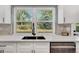 Bright kitchen sink features stainless steel appliances and a large window with backyard views at 6842 Garland St, Arvada, CO 80004