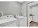 Laundry room with adjacent bathroom and a side-by-side washer and dryer in a well-lit space at 6842 Garland St, Arvada, CO 80004