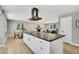 Open-concept living space featuring a modern kitchen, dining area, and a living room with a fireplace at 6842 Garland St, Arvada, CO 80004