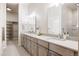 Well-lit bathroom with double vanity, modern fixtures and walk-in closet at 9091 E 61St Ave, Denver, CO 80238