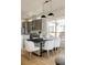Kitchen with sleek appliances, modern lighting, and a dark dining table with bright white chairs at 9091 E 61St Ave, Denver, CO 80238