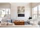 Cozy living area featuring a fireplace, large windows, and stylish, neutral-toned furniture at 9091 E 61St Ave, Denver, CO 80238