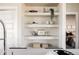 Stylish built-in shelves with decorative items and view into the main bedroom at 9091 E 61St Ave, Denver, CO 80238