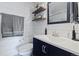 Well-lit bathroom with a navy blue vanity, shiplap walls and floating shelves at 2540 E Geddes Pl, Centennial, CO 80122