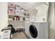 Functional laundry room with washer, dryer, storage shelves, and cleaning supplies at 2540 E Geddes Pl, Centennial, CO 80122