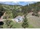 Aerial view of the home surrounded by green trees and a rolling landscape at 100 Wildcat Ln, Boulder, CO 80304