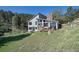 Mountain home with stone chimney, outdoor deck, mature trees, and grassy area at 100 Wildcat Ln, Boulder, CO 80304