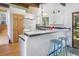 Bright kitchen featuring white cabinets, a breakfast bar with seating, and a sliding glass door to the outside at 100 Wildcat Ln, Boulder, CO 80304