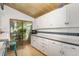 Kitchen featuring white cabinets, sleek countertops, wood floors, and access to outdoor patio through sliding door at 100 Wildcat Ln, Boulder, CO 80304