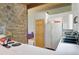 Kitchen with stone accent wall, white appliances, and access to living space, providing a cozy and functional layout at 100 Wildcat Ln, Boulder, CO 80304